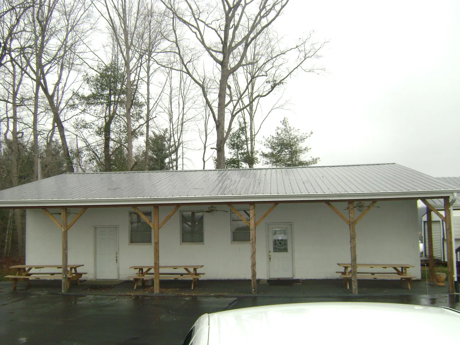 Gray metal roof over a block building with a timber post porch in Alpine